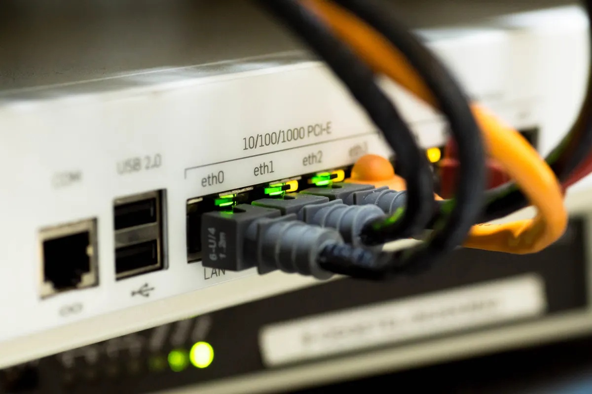 Ethernetkabels aangesloten op netwerkpoorten met groene indicatielampjes